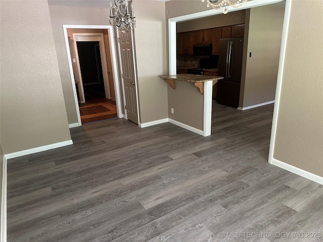905 Brookside Dr, Durant, OK 74701 - unfurnished dining area with a chandelier, baseboards, and dark wood finished floors