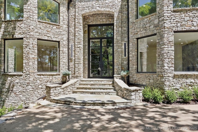 5011 E 84th St, Tulsa, OK 74137 - doorway to property featuring french doors and stone siding