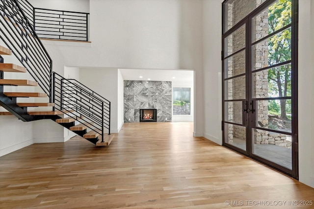 5011 E 84th St, Tulsa, OK 74137 - unfurnished living room with a towering ceiling, wood finished floors, stairway, baseboards, and plenty of natural light