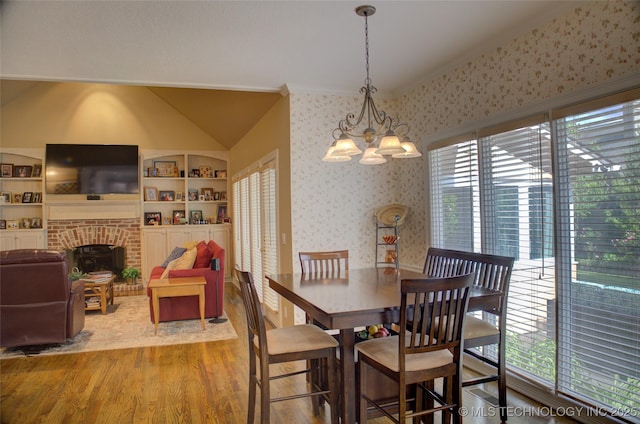 5140 E 107th Pl, Tulsa, OK 74137 - dining space featuring wood finished floors, wallpapered walls, a chandelier, lofted ceiling, and built in features