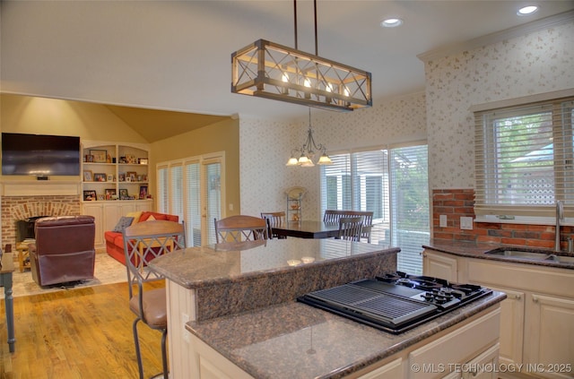 5140 E 107th Pl, Tulsa, OK 74137 - kitchen featuring a sink, light wood-style flooring, white cabinetry, pendant lighting, and stovetop with downdraft