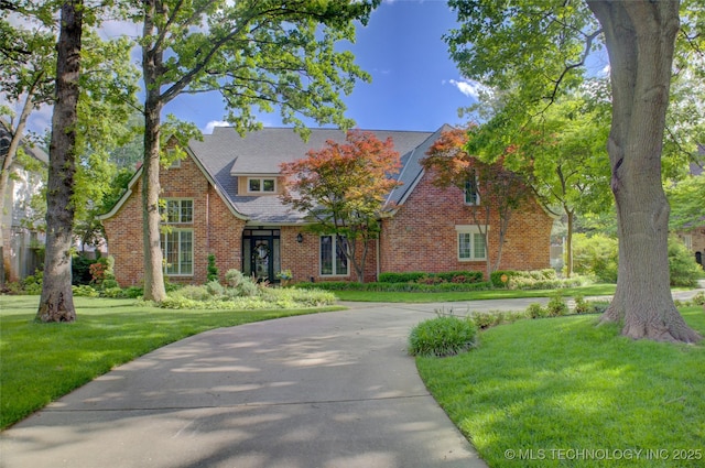 5140 E 107th Pl, Tulsa, OK 74137 - tudor-style house with a front yard and brick siding
