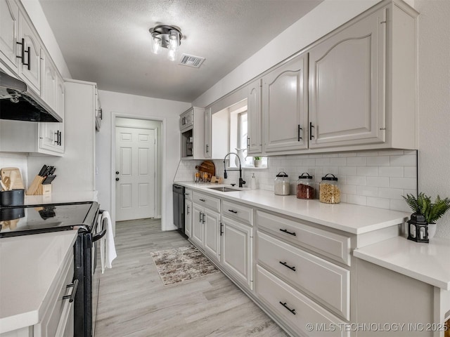 5015 S 89th E Pl, Tulsa, OK 74145 - kitchen with electric range oven, decorative backsplash, light wood-style flooring, dishwasher, and a textured ceiling
