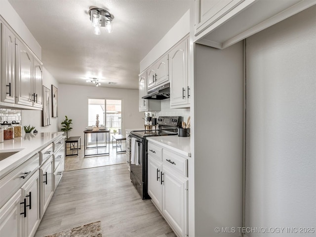 5015 S 89th E Pl, Tulsa, OK 74145 - kitchen featuring electric range, under cabinet range hood, backsplash, and white cabinets