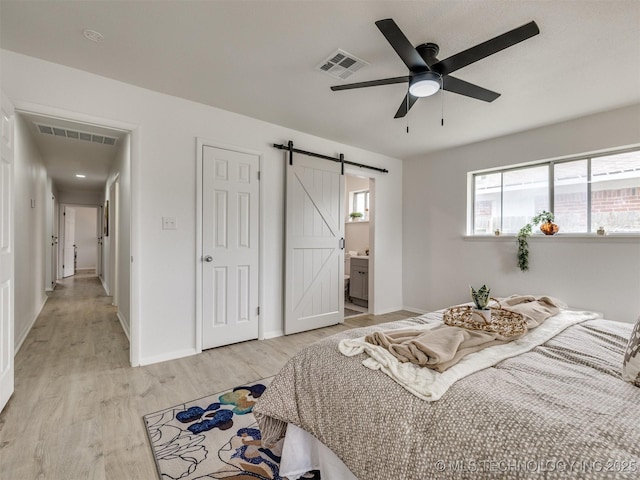 5015 S 89th E Pl, Tulsa, OK 74145 - bedroom featuring a barn door, light wood-style flooring, ensuite bath, and ceiling fan