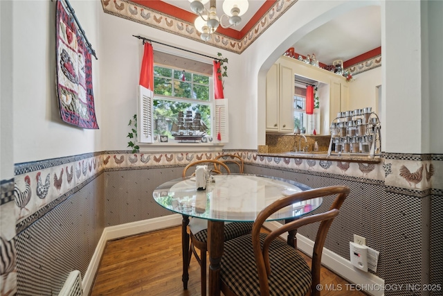 2403 S Troost Ave, Tulsa, OK 74114 - dining room featuring wainscoting, arched walkways, wood finished floors, and a chandelier
