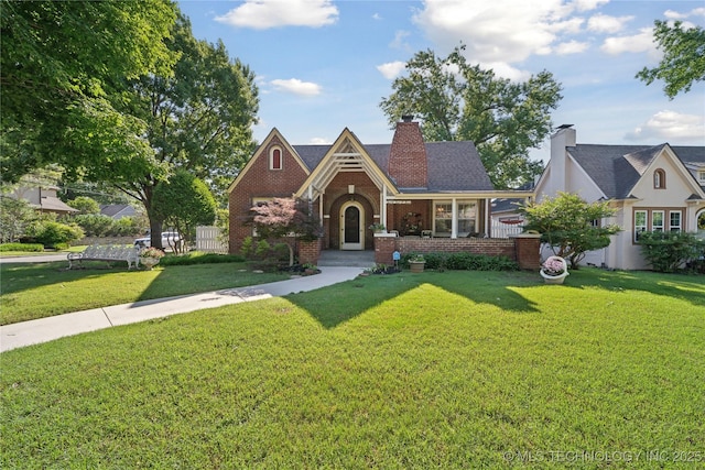 2403 S Troost Ave, Tulsa, OK 74114 - tudor house with brick siding, a front yard, and a chimney