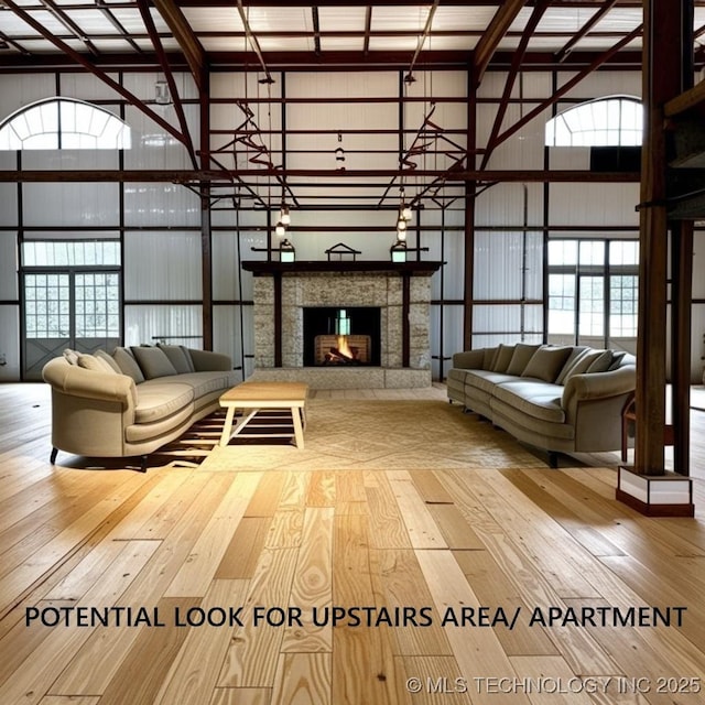 199 Shadow Ln, Ardmore, OK 73401 - living area featuring hardwood / wood-style flooring, a high ceiling, and a stone fireplace