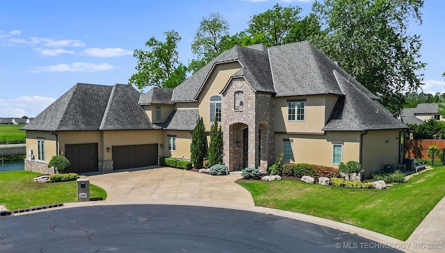 12014 S Kingston Pl, Tulsa, OK 74137 - french country inspired facade featuring stucco siding, stone siding, an attached garage, and concrete driveway
