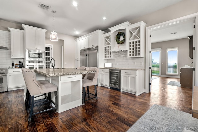 12014 S Kingston Pl, Tulsa, OK 74137 - kitchen with appliances with stainless steel finishes, wine cooler, tasteful backsplash, white cabinets, and recessed lighting