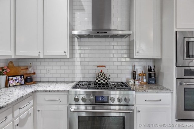 12014 S Kingston Pl, Tulsa, OK 74137 - kitchen with stainless steel appliances, wall chimney range hood, white cabinets, and decorative backsplash
