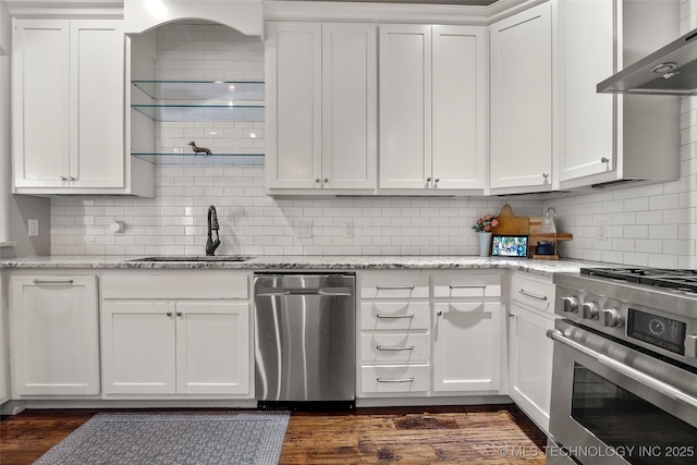 12014 S Kingston Pl, Tulsa, OK 74137 - kitchen with stainless steel appliances, a sink, wall chimney exhaust hood, white cabinetry, and tasteful backsplash