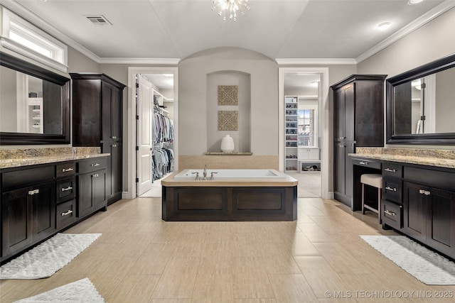 12014 S Kingston Pl, Tulsa, OK 74137 - bathroom featuring a garden tub, a walk in closet, vanity, and ornamental molding
