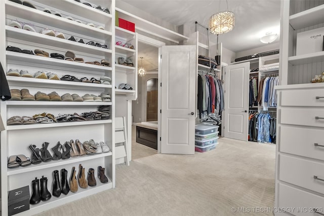 12014 S Kingston Pl, Tulsa, OK 74137 - spacious closet with light carpet, arched walkways, and a chandelier