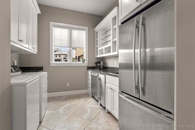 12014 S Kingston Pl, Tulsa, OK 74137 - kitchen featuring appliances with stainless steel finishes, washing machine and clothes dryer, white cabinets, baseboards, and dark countertops