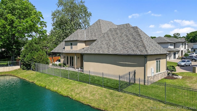 12014 S Kingston Pl, Tulsa, OK 74137 - rear view of house featuring stucco siding, a water view, stone siding, and a shingled roof