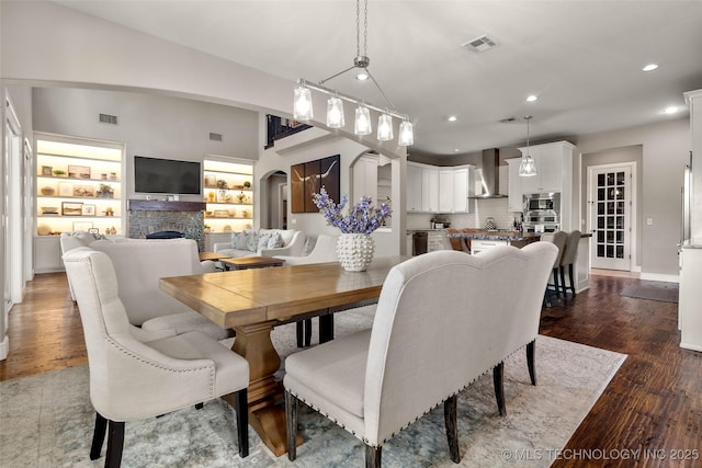 12014 S Kingston Pl, Tulsa, OK 74137 - dining room featuring recessed lighting, arched walkways, dark wood-style flooring, a fireplace, and baseboards