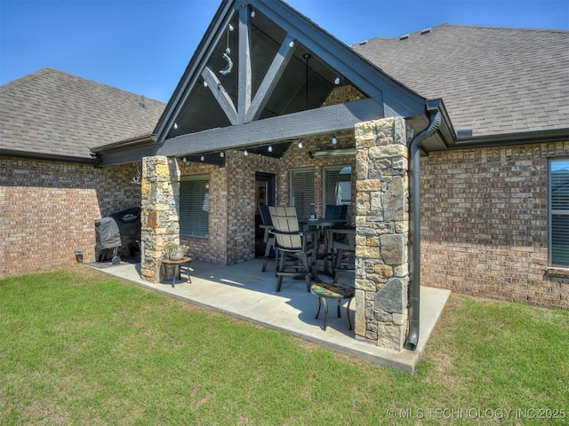 2915 E Rockford Pl, Broken Arrow, OK 74014 - rear view of house with brick siding, a patio area, a lawn, and a shingled roof