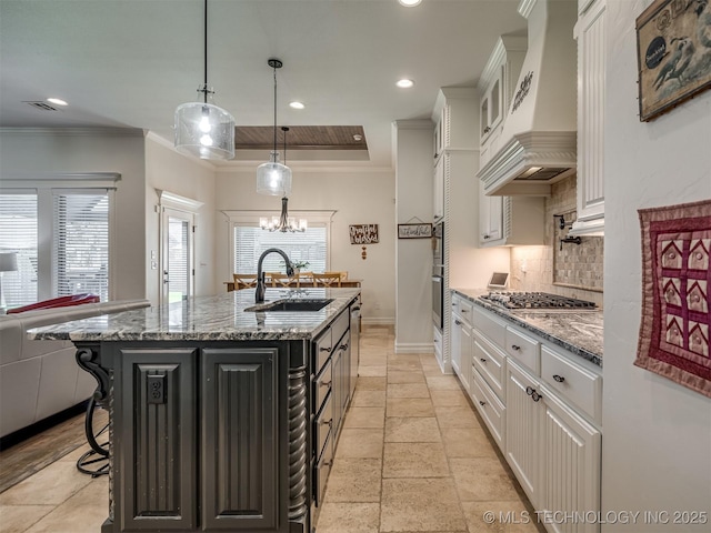 2915 E Rockford Pl, Broken Arrow, OK 74014 - kitchen featuring custom range hood, stainless steel gas stovetop, a sink, decorative backsplash, and white cabinetry