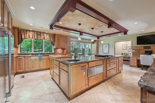 3898 E 72nd St, Tulsa, OK 74136 - kitchen with a warming drawer, dark stone counters, an island with sink, appliances with stainless steel finishes, and recessed lighting