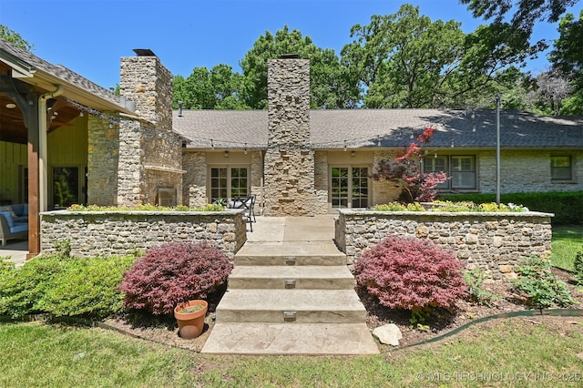 3898 E 72nd St, Tulsa, OK 74136 - back of house with a chimney, stone siding, roof with shingles, and a patio