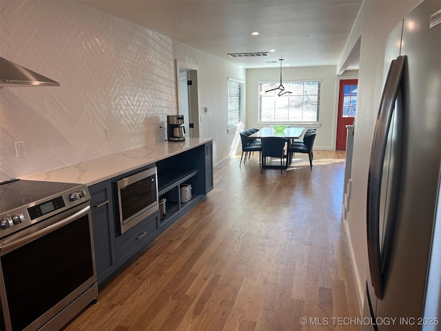 56648 Bloomer Rd, Afton, OK 74331 - kitchen featuring stainless steel appliances, baseboards, wood finished floors, light stone counters, and open shelves