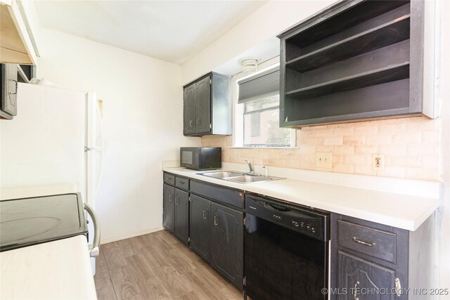 2207 Hillcrest Ct, Durant, OK 74701 - kitchen with black appliances, a sink, backsplash, light wood-type flooring, and light countertops