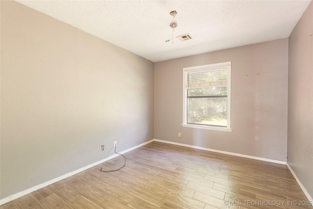 2207 Hillcrest Ct, Durant, OK 74701 - spare room featuring light wood-style flooring, a textured ceiling, and baseboards