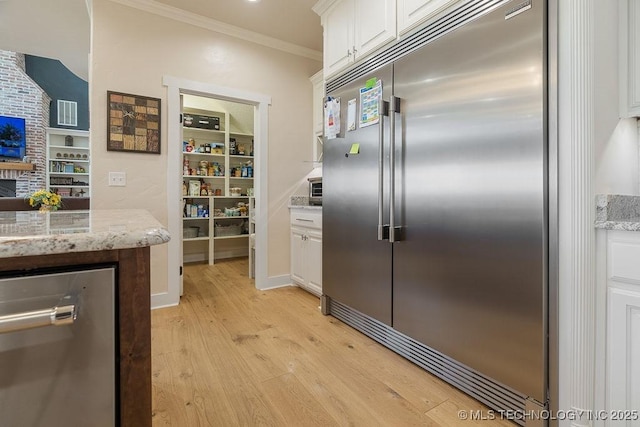 589 Three Mile Rd, Durant, OK 74701 - kitchen featuring appliances with stainless steel finishes, light wood-style flooring, white cabinetry, ornamental molding, and light stone counters