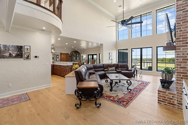 589 Three Mile Rd, Durant, OK 74701 - living area with light wood finished floors, a ceiling fan, baseboards, a high ceiling, and ornamental molding