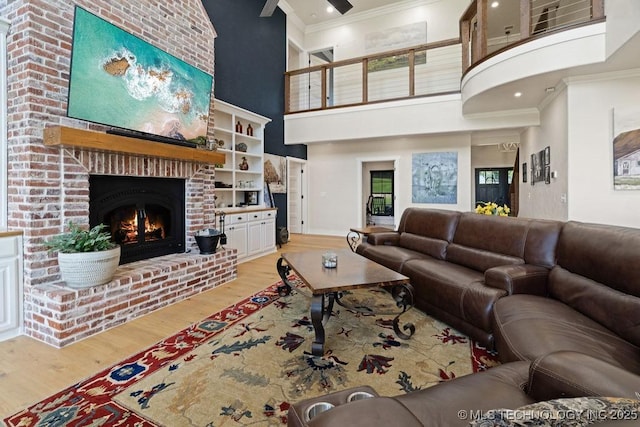 589 Three Mile Rd, Durant, OK 74701 - living room with ornamental molding, a brick fireplace, wood finished floors, a towering ceiling, and baseboards