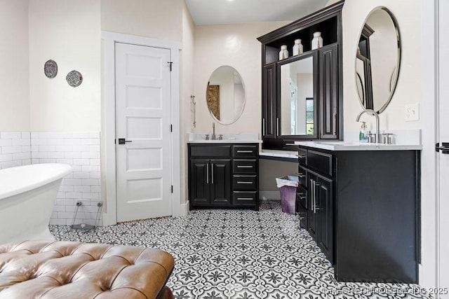 589 Three Mile Rd, Durant, OK 74701 - bathroom featuring two vanities, a freestanding tub, tile walls, wainscoting, and tile patterned floors