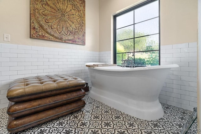 589 Three Mile Rd, Durant, OK 74701 - full bathroom featuring tile walls, a wainscoted wall, a soaking tub, and tile patterned floors