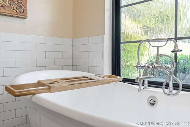 589 Three Mile Rd, Durant, OK 74701 - bathroom featuring tile walls and a soaking tub