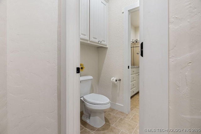 589 Three Mile Rd, Durant, OK 74701 - bathroom featuring tile patterned flooring, toilet, and a textured wall