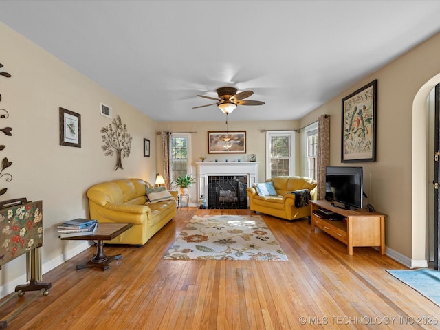 1626 S Dewey Ave, Bartlesville, OK 74003 - living area featuring a fireplace, hardwood / wood-style flooring, a ceiling fan, arched walkways, and baseboards
