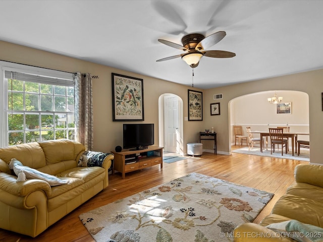 1626 S Dewey Ave, Bartlesville, OK 74003 - living room with arched walkways, a chandelier, wood finished floors, and a ceiling fan