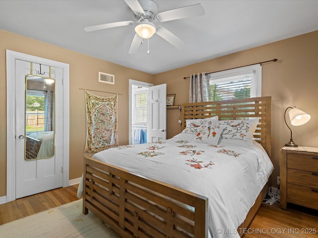 1626 S Dewey Ave, Bartlesville, OK 74003 - bedroom featuring multiple windows, light wood-style floors, baseboards, and ceiling fan