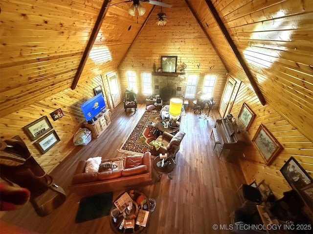 7905 Hornbeam Rd, Henryetta, OK 74437 - living area with wood walls, wooden ceiling with exposed beams, wood-type flooring, high vaulted ceiling, and a ceiling fan