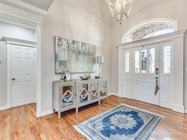 609 E Pensacola St, Broken Arrow, OK 74011 - foyer with wood finished floors, a chandelier, baseboards, a towering ceiling, and crown molding