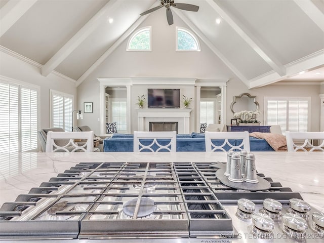 609 E Pensacola St, Broken Arrow, OK 74011 - living area featuring high vaulted ceiling, ceiling fan, a glass covered fireplace, beamed ceiling, and healthy amount of natural light