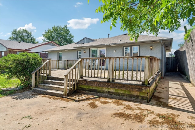 8009 E 2nd St, Tulsa, OK 74112 - back of property with brick siding, a wooden deck, and roof with shingles