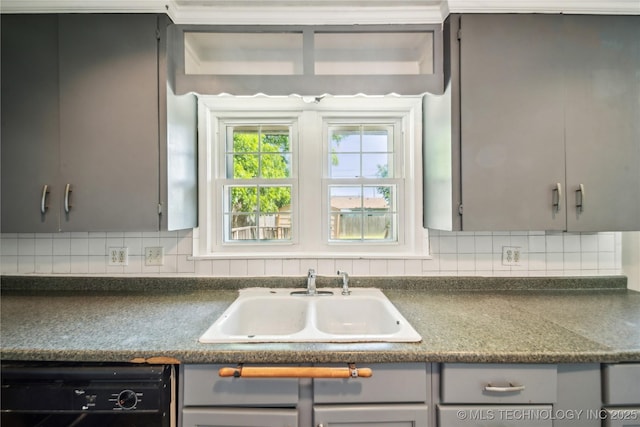 8009 E 2nd St, Tulsa, OK 74112 - kitchen with gray cabinetry, dishwasher, a sink, and dark countertops