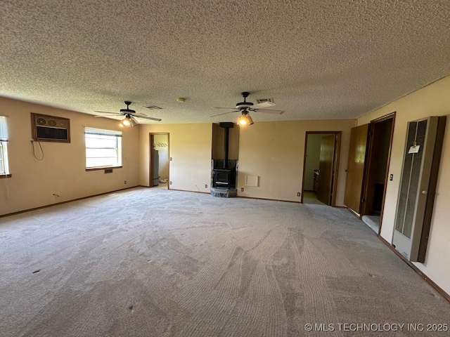 109948 S 4155th Rd, Checotah, OK 74426 - unfurnished living room with a wood stove, a heating unit, a ceiling fan, a textured ceiling, and light colored carpet