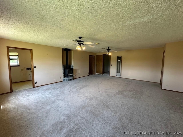 109948 S 4155th Rd, Checotah, OK 74426 - unfurnished living room with a wood stove, ceiling fan, baseboards, light carpet, and a textured ceiling