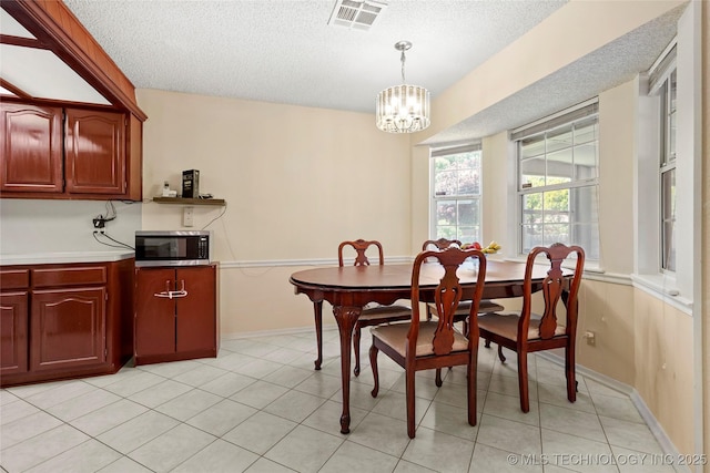 12013 E 27th St, Tulsa, OK 74129 - dining space with a textured ceiling, a chandelier, and baseboards