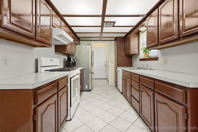 12013 E 27th St, Tulsa, OK 74129 - kitchen with white appliances, a sink, under cabinet range hood, light countertops, and light tile patterned floors