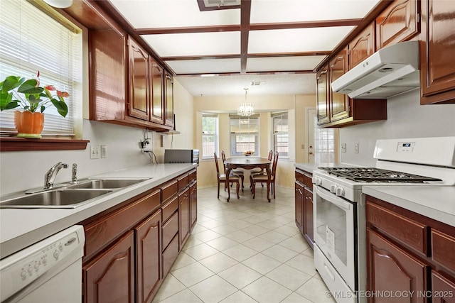 12013 E 27th St, Tulsa, OK 74129 - kitchen with white appliances, under cabinet range hood, a sink, and light countertops