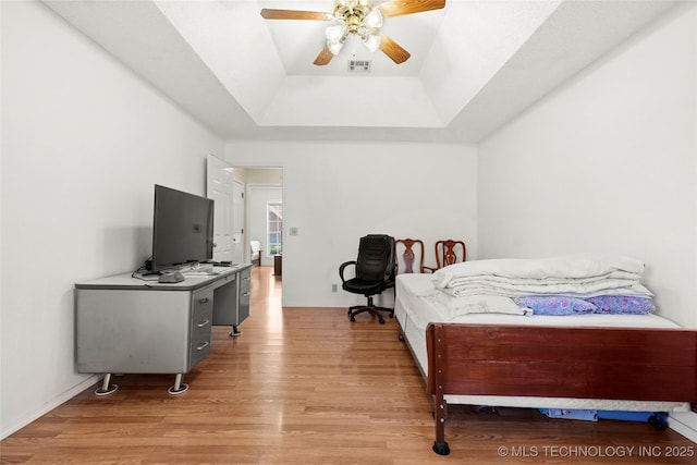 12013 E 27th St, Tulsa, OK 74129 - bedroom with a tray ceiling, light wood finished floors, ceiling fan, and a desk