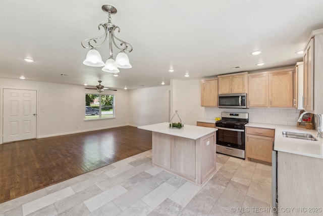 201 W 9th St, Claremore, OK 74017 - kitchen featuring appliances with stainless steel finishes, a sink, light brown cabinetry, light countertops, and open floor plan